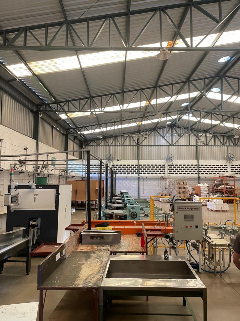 Galpão industrial com linha de máquinas e estrutura metálica