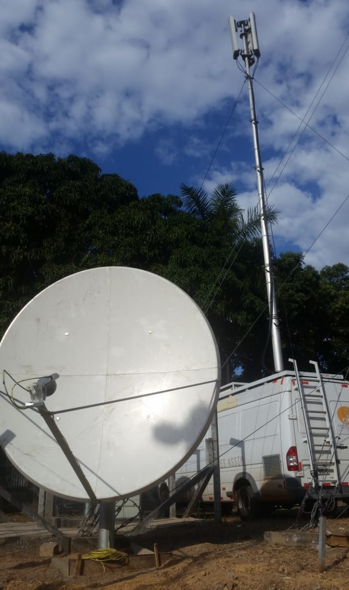 Antena parabólica e mastro com antenas instalados junto a veículo de apoio em Muquém